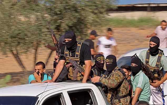 Palestinian Islamic Jihad terrorists are seen on their way to cross the Israel-Gaza border fence from Khan Younis during the Hamas-led attack on October 7.