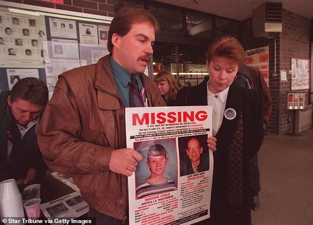 Mullenberg's mother, Monica, and stepfather, Jake Bourget, hold a missing person sign after Jessyca was kidnapped by a neighbor in Eau Claire, Wisconsin.