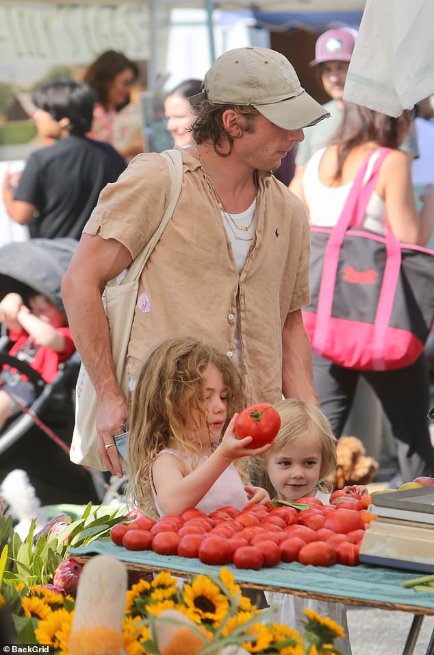 The hands-on dad could be seen checking out the fruits and vegetables with his daughters Ezer, five, and Dolores, three.