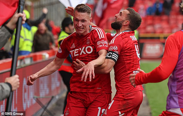 Captain Graeme Shinnie helps Croatian new boy Palaversa celebrate his dramatic intervention