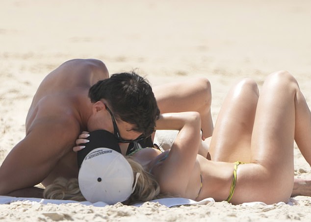 The couple sat on the sand to sunbathe and Soldo leaned in to share a kiss with his girlfriend.