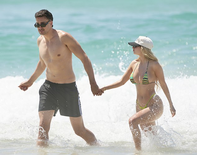 The couple appear to be enjoying their summer holiday on the Gold Coast and were seen holding hands while enjoying a dip in the sea.