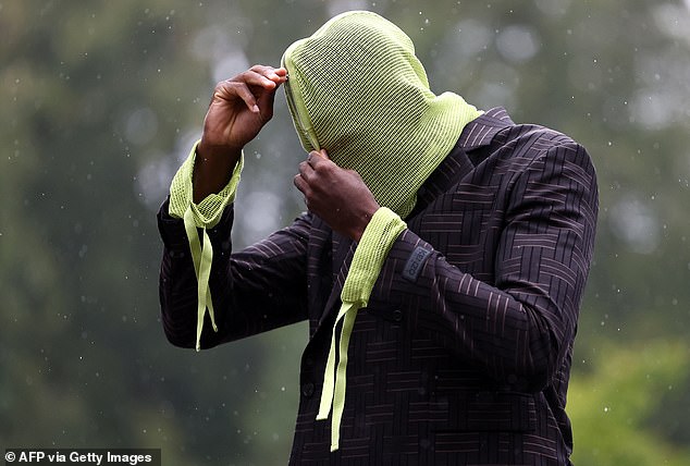 The Liverpool star arrived with a strange yellow hoodie that covered his face.