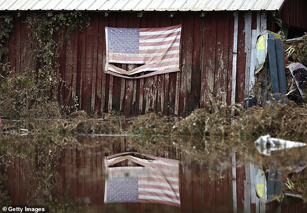 An American flag is reflected in the waters left over from Hurricane Helene on October 4.