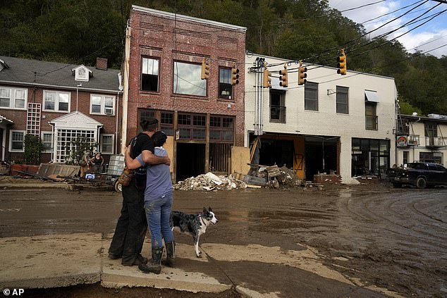 Resident Anne Schneider, right, hugs her friend Eddy Sampson as they survey the damage left behind by Hurricane Helene on Tuesday, Oct. 1, 2024, in Marshall, North Carolina.