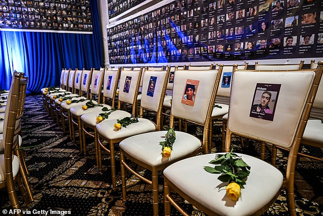 Empty chairs with flowers and photographs of the victims of the Hamas attack on Israel before the memorial service.