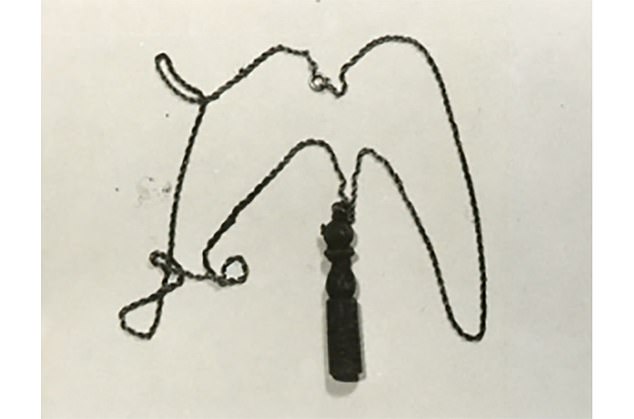 The unidentified girl was wearing a gold-colored metal chain with a brown wooden bolo-shaped pendant, which was usually worn by recruits who had completed their military service.