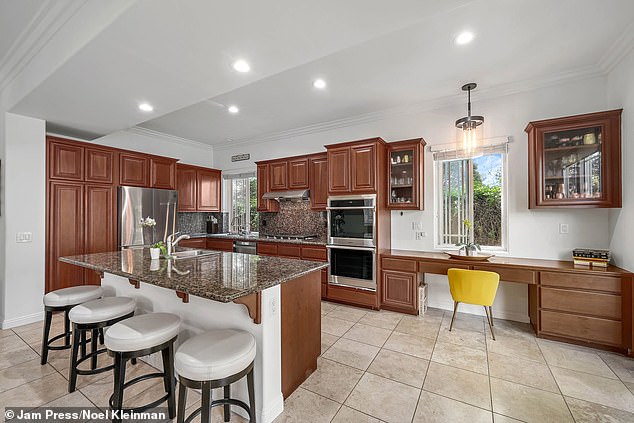 The kitchen is complete with granite counters, a spacious island, and custom cabinetry.