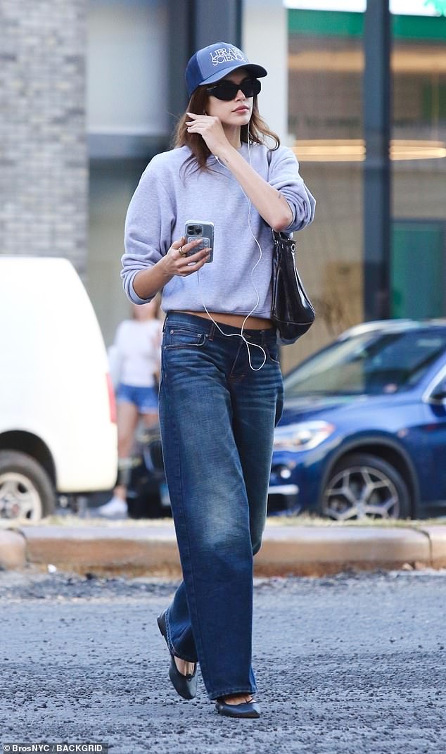 Cindy Crawford's lookalike daughter, 23, wore a crew-neck sweatshirt that showed off an inch of her taut midriff.