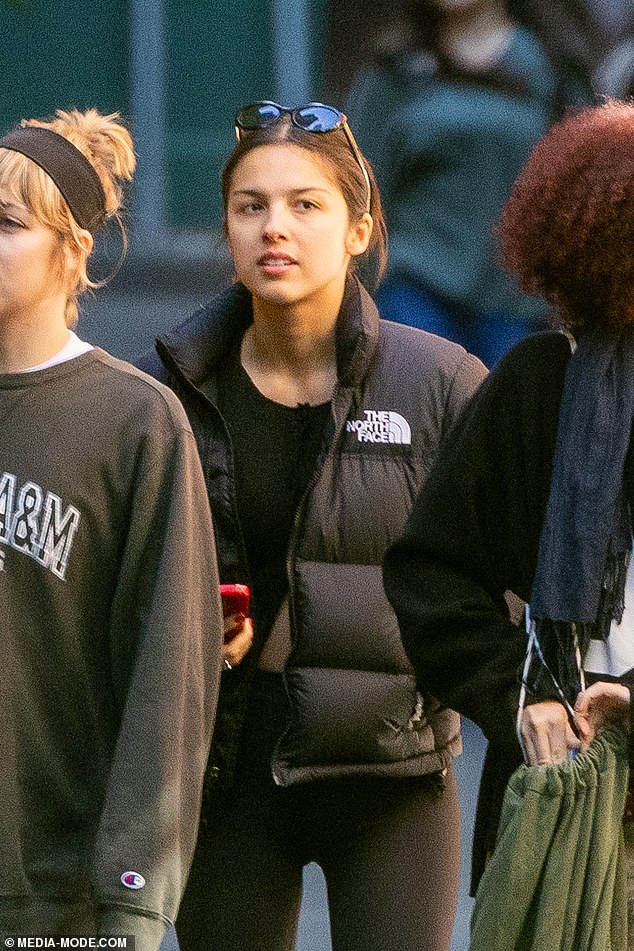 Olivia brushed her hair out of her face and had a pair of sunglasses on top of her head, while she carried a designer bag over one shoulder.