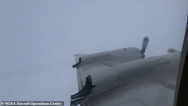 Outside the plane, the sky was gray and rain pounded on the window.