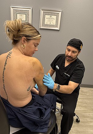 Dr. Nájera inspects Ashley's arms after her liposuction.