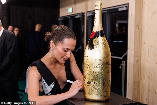 He also signed a huge bottle of champagne.