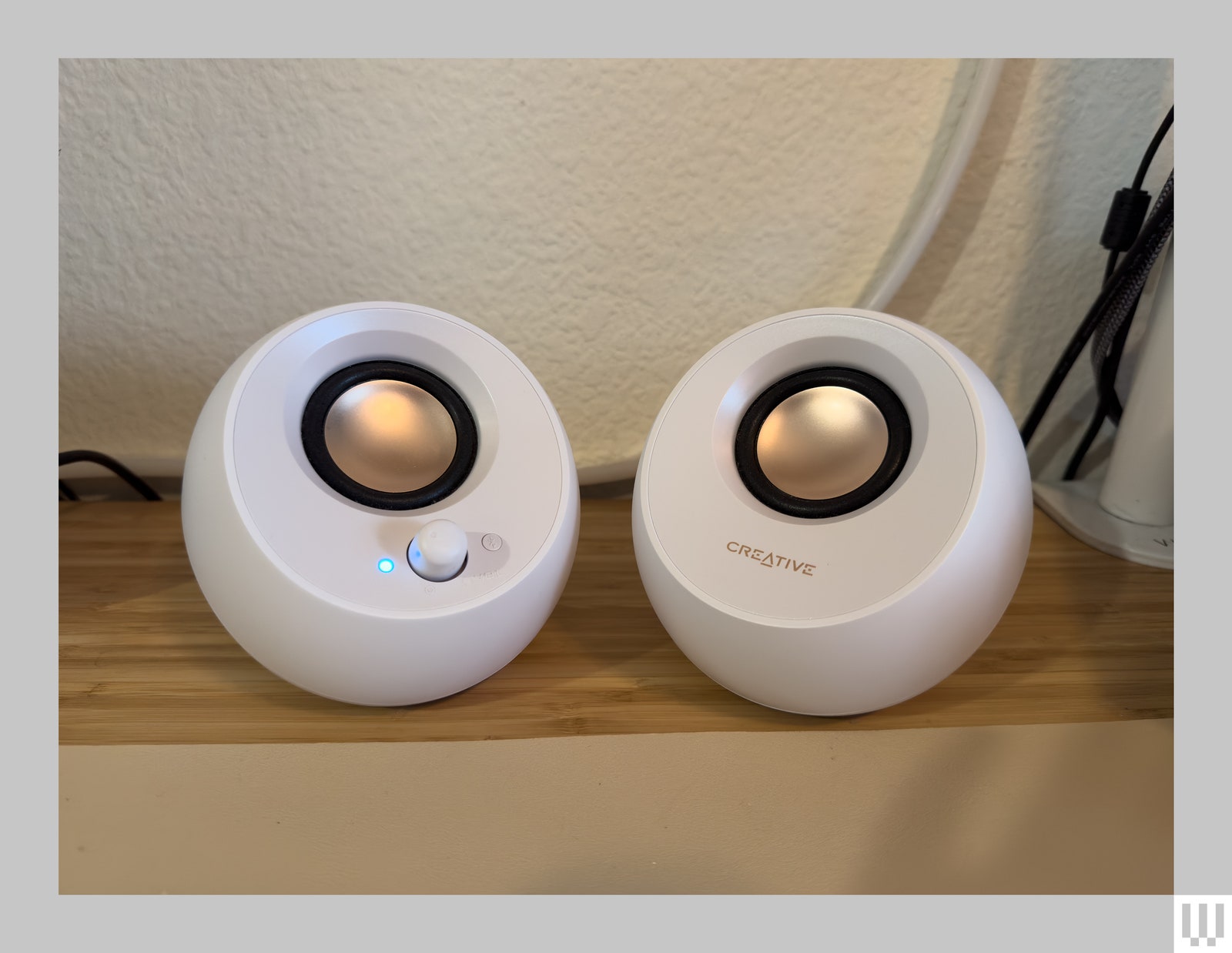 2 white round speakers with gold centers.