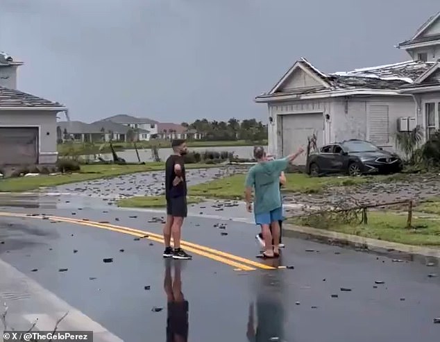 Neighbors discuss the damage in the street