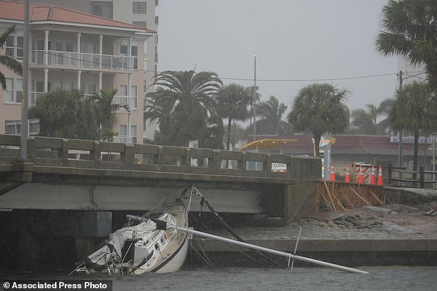 A boat damaged by Hurricane Helene rests against a bridge ahead of the landfall of Hurricane Milton, in South Pasadena, Fla., Wednesday, Oct. 9, 2024. (AP Photo/Rebecca Blackwell)