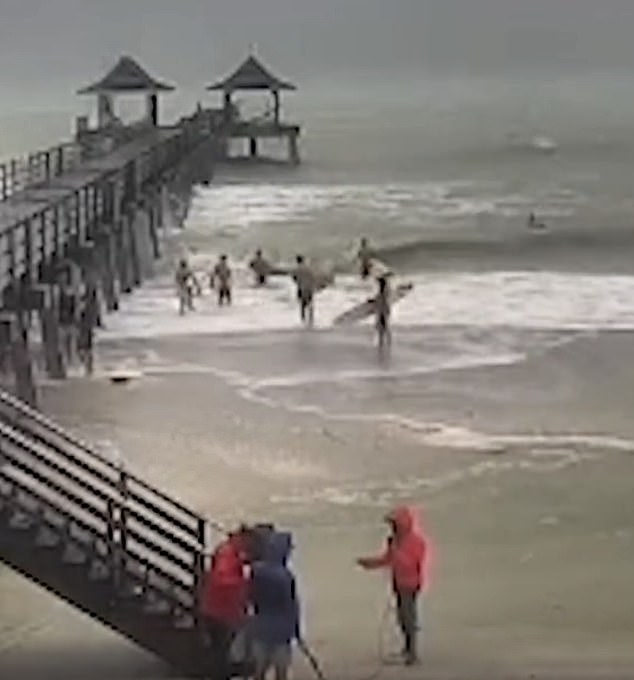 A group of surfers are seen hitting the strong waves in Key West on Wednesday as Milton pushes ahead