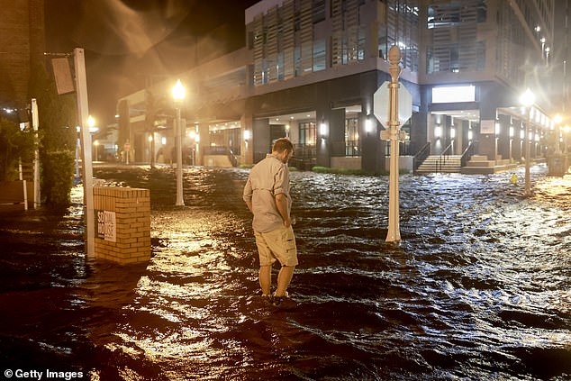 A man walks through water that flooded the street after Hurricane Milton made landfall in the Sarasota area on Wednesday.