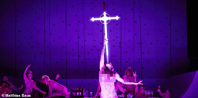 In one scene, naked tattooed performers climb on a table, drink wine and sing, while another raises a crucifix-shaped sword and shoves it down their throat.