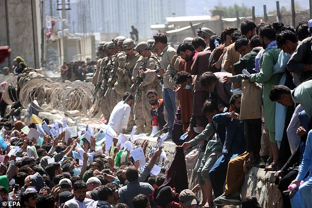 Afghans struggle to reach foreign forces to show their credentials and flee the country in front of the Hamid Karzai International Airport, in Kabul, Afghanistan, on August 26, 2021. At least 13 people, including children, were killed in an explosion outside from the airport on August 26. The explosion occurred outside Abbey Gate and follows recent security warnings about attacks ahead of the August 31 deadline for the withdrawal of US troops.