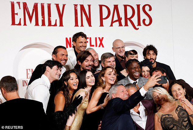 The Emily in Paris cast poses for a selfie while attending the European premiere of the show's fourth season.