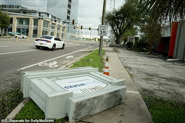 A downed business sign seen on the sidewalk of N Nines Avenue