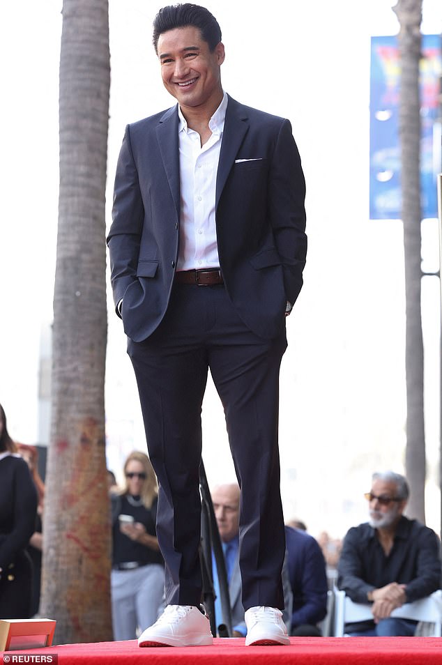 The Saved by the Bell alum, 51, looked dapper in a classic navy suit paired with an unbuttoned white Oxford shirt, flashing his trademark megawatt smile during the afternoon ceremony on Hollywood Boulevard.