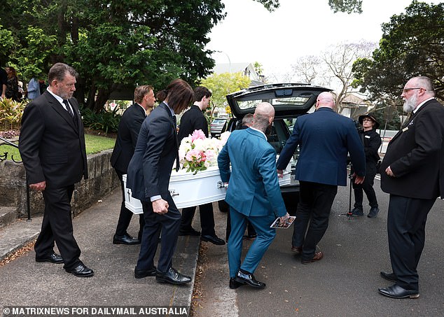 Father Daniel and Brother James (back) help carry Savana's coffin for the last time.