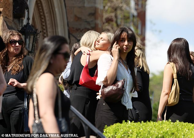 Mourners comfort each other in front of St. Mark's Church