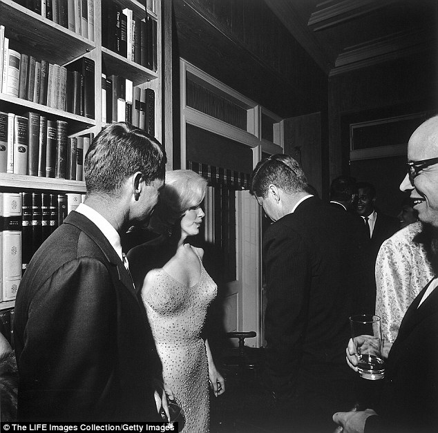 During a party at film executive Arthur Krim's home, Marilyn Monroe comes between Bobby and JFK in New York in 1962. Both brothers had affairs with Monroe, possibly at the same time.