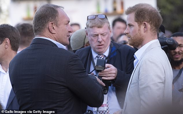 An unhappy looking Prince Harry with photographers during his tour of South Africa in 2019