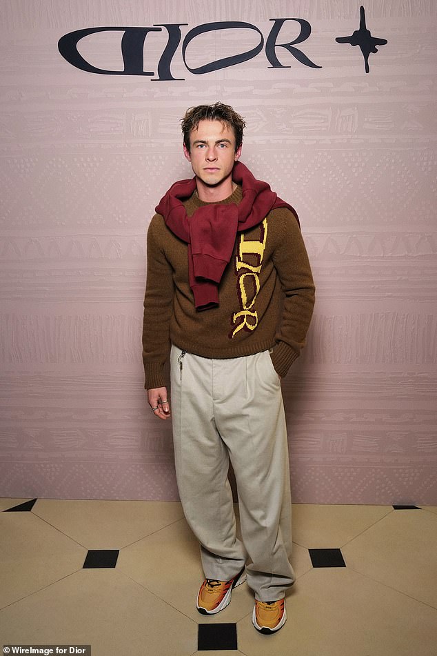 Ben Radcliffe wore a brown knit sweater, wide-leg pants and orange sneakers.