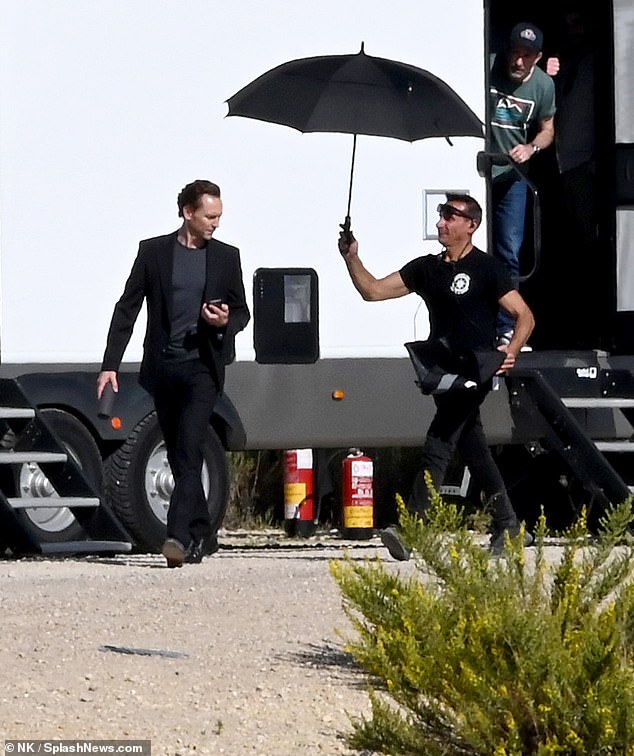 A crew member covered Tom with an umbrella to protect him from the sun.