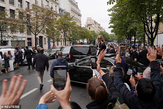 Fans take photos of Canadian singer Celine Dion outside Le Royal Monceau in Paris on July 27.