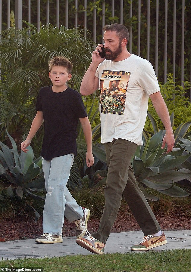 He was accompanied by his 12-year-old son Samuel as he took a call while showing a tense expression.