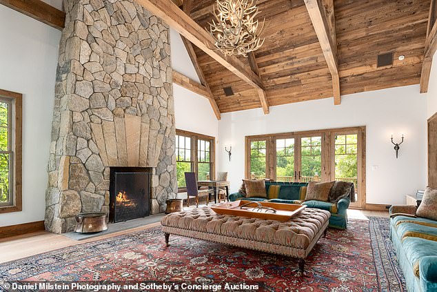 A living room is complete with a huge stone fireplace.