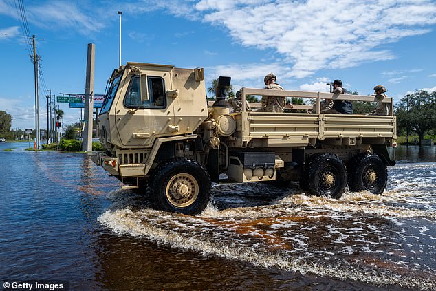 A National Guard truck plows through water on a highway Oct. 11 after the Anclote River flooded homes, businesses and roads as Hurricane Milton passed through Florida.