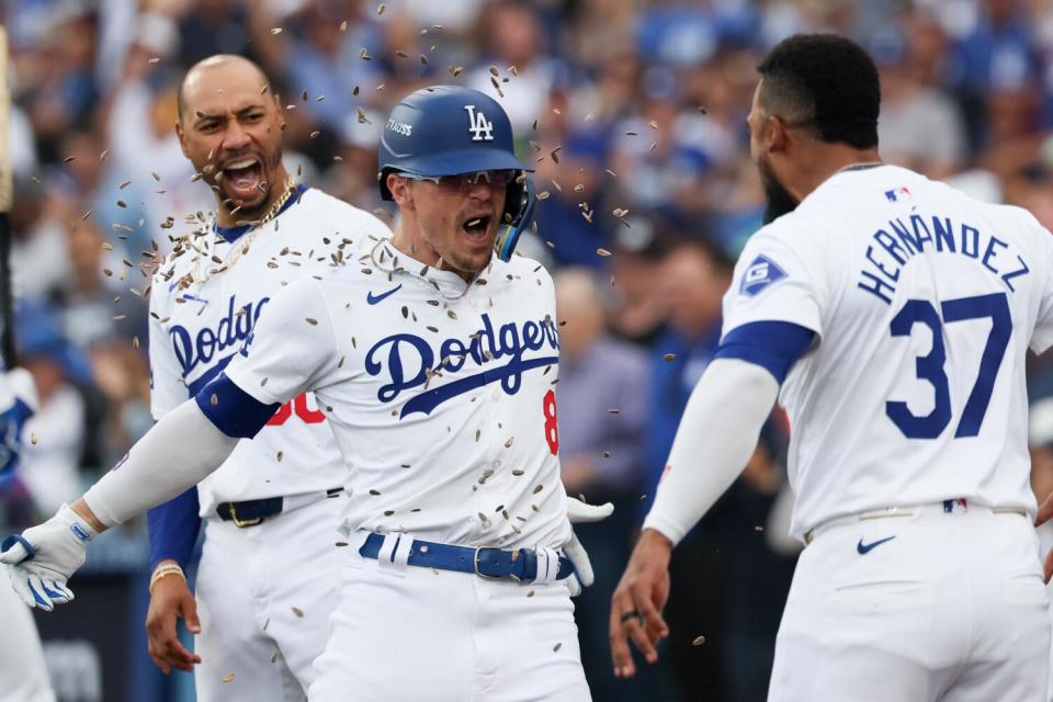 Kiké Hernández, center, celebrates with Mookie Betts and Teoscar Hernández after hitting a solo home run for the Dodgers.