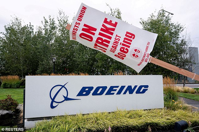 A strike sign hangs from a pole near a Boeing sign as Boeing factory workers and supporters gather on a picket line near the Renton, Washington factory.