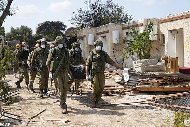 Israeli soldiers carry bodies of murdered Israelis at Kibbutz Kfar Aza on Tuesday, October 10, 2023.