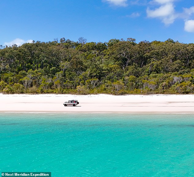 The couple is pictured here driving along a beach on K'gari Island in Australia.