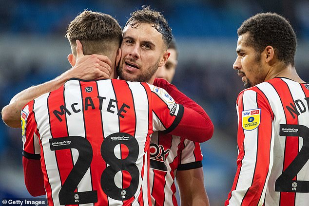 Baldock pictured (centre) hugging teammate McAtee in November 2022, when they played together for Sheffield United in the Championship.