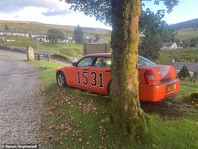 A replica of the 'General Lee' muscle car from the Dukes of Hazzard television series stands at the entrance to the Wanlockhead Inn