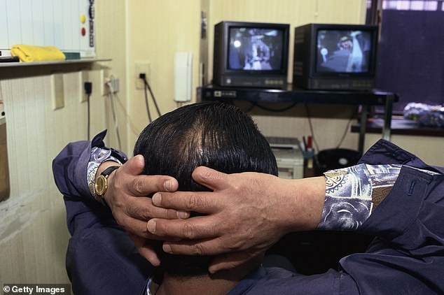 In this practice, people cut off their fingers as a gesture of apology for a serious mistake. It is currently unclear why the gangster cut off his finger (File image of a yakuza member looking at the security monitors)