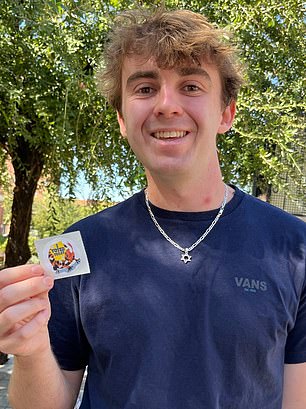 Benjamin Sorensen, 19, holds a sticker that says 