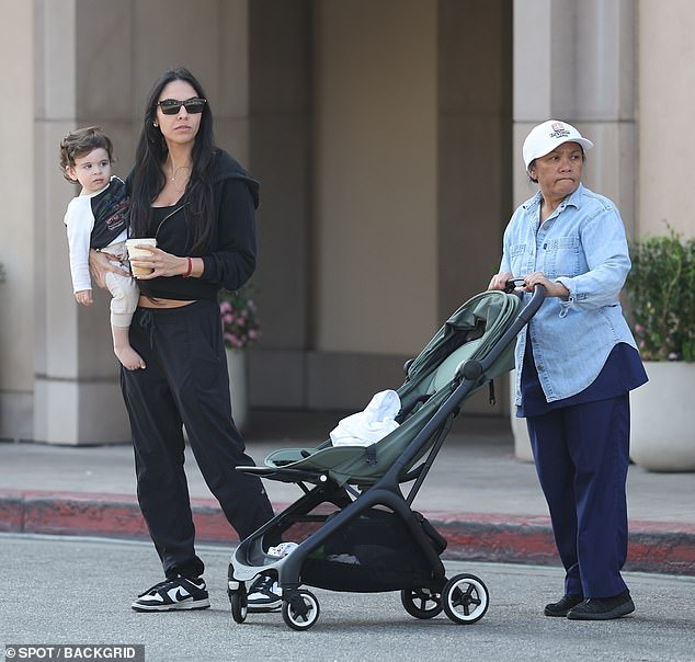 Dressed in sweatpants, a hoodie and sneakers, the film producer drank a smoothie while at the coffee shop and then took her son in her arms and began walking with her babysitter.