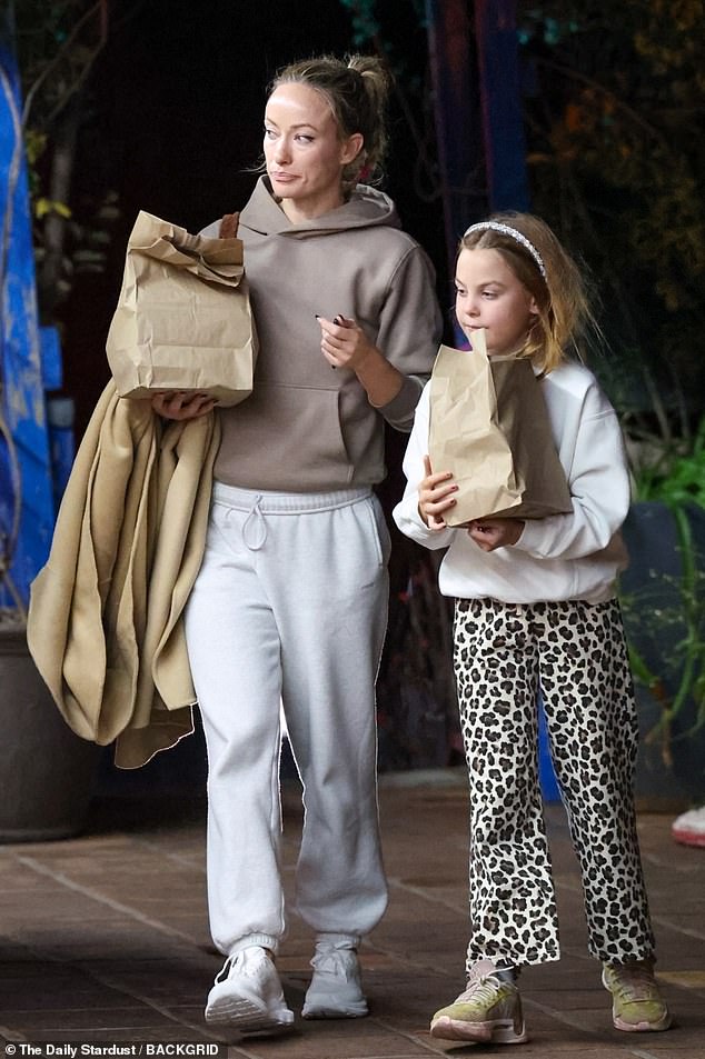 For his outing, the Don't Worry Darling director donned a stylish trench coat over a taupe hoodie. She also rocked a pair of light gray baggy sweatpants and all-white sneakers.