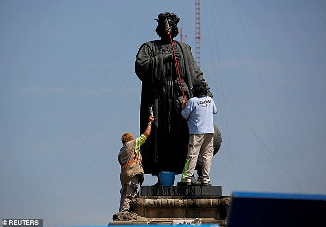 Workers clean the statue of Italian explorer Christopher Columbus, also known as Christopher Columbus, surrounded by a metal fence during Columbus Day, or Dia de la Raza, in remembrance of when Columbus arrived in the Americas, in Mexico City . Mexico October 12, 2020