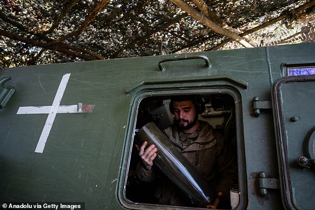 A Ukrainian serviceman from the 30th Artillery Brigade checks the ammunition of 2S3 Akatsiya 152