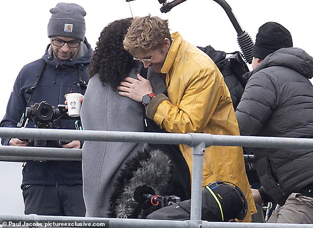 In the scenes, Ryan is seen holding a phone while listening to something through a pair of wired headphones. He was then seen hugging his co-star, who has not yet been identified.